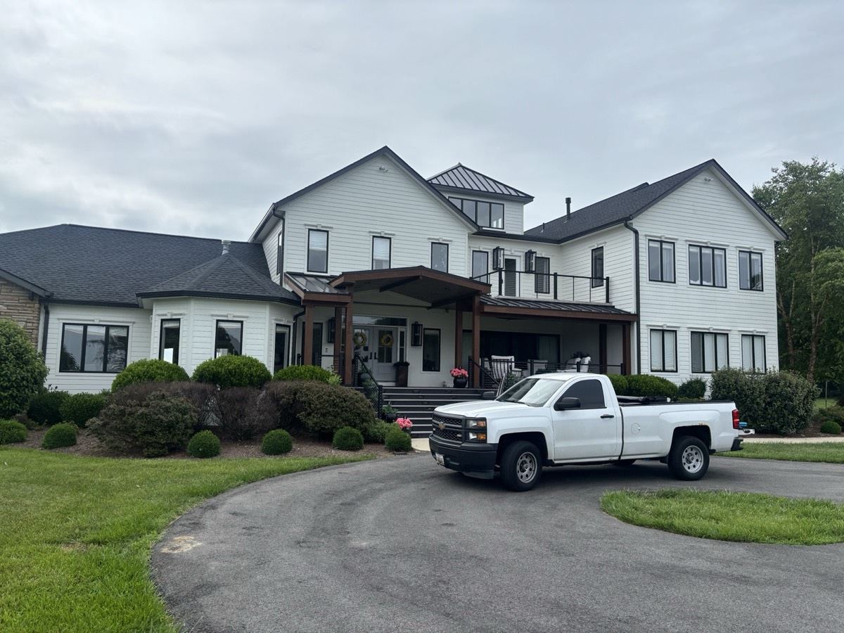 Large white farmhouse-style home after a full exterior window cleaning by WindowBuddy